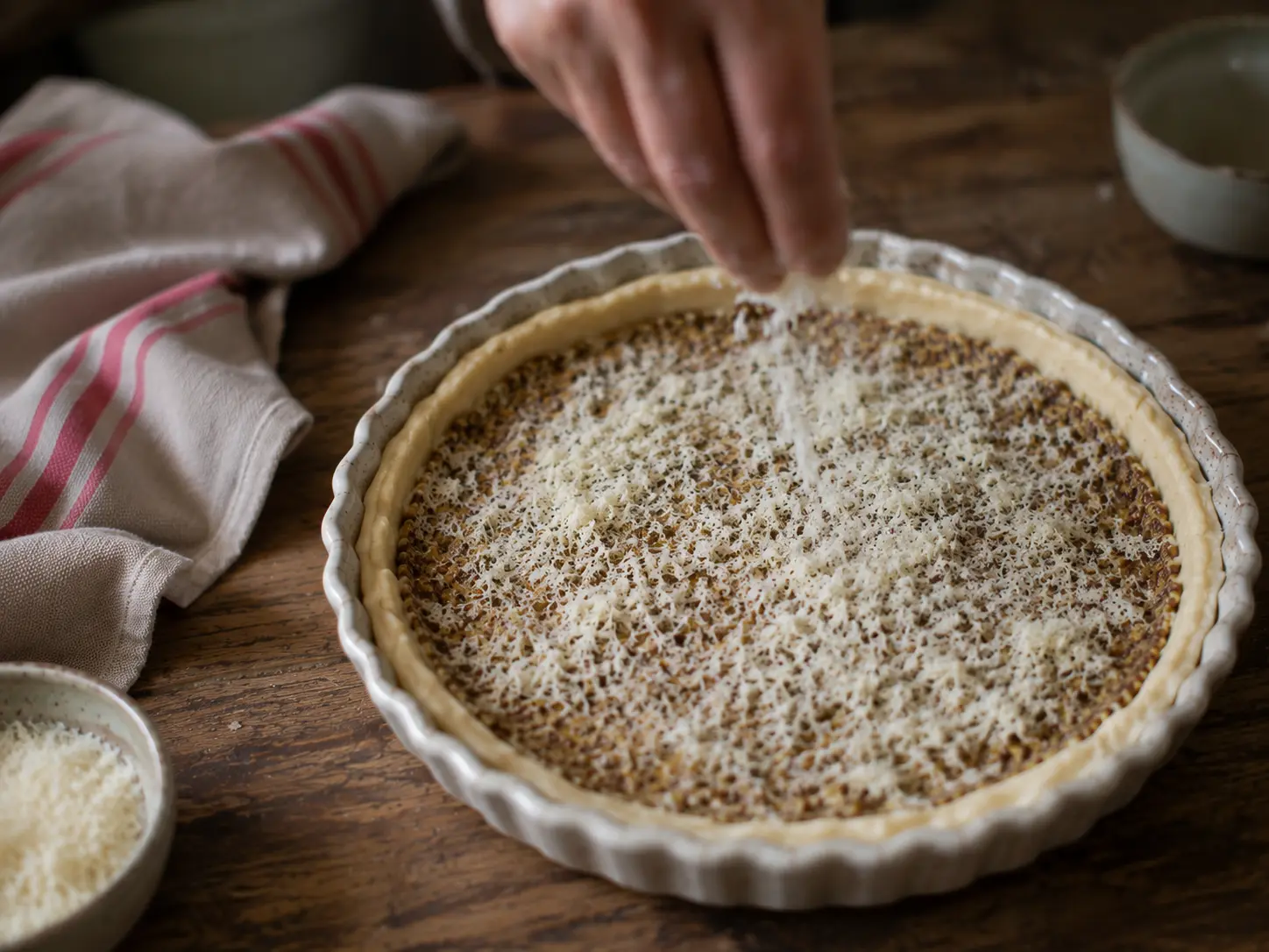 Moutarde et parmesan étalés sur le fond de tarte avant les tomates