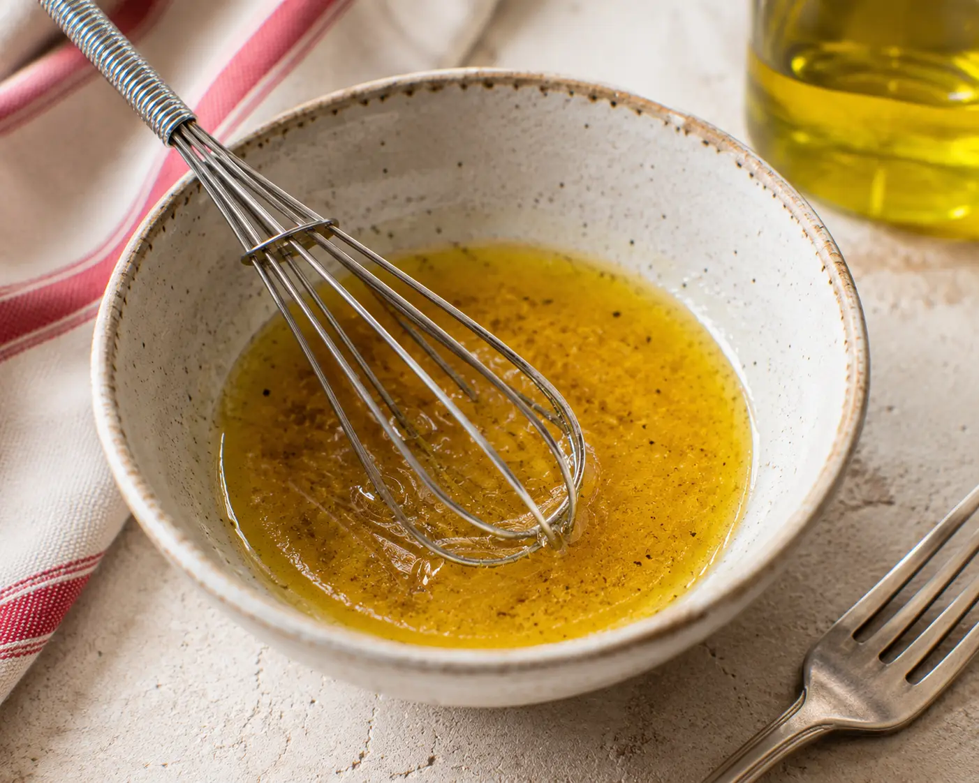 Vinaigrette d'huile d'olive et de vinaigre fouettée dans un bol