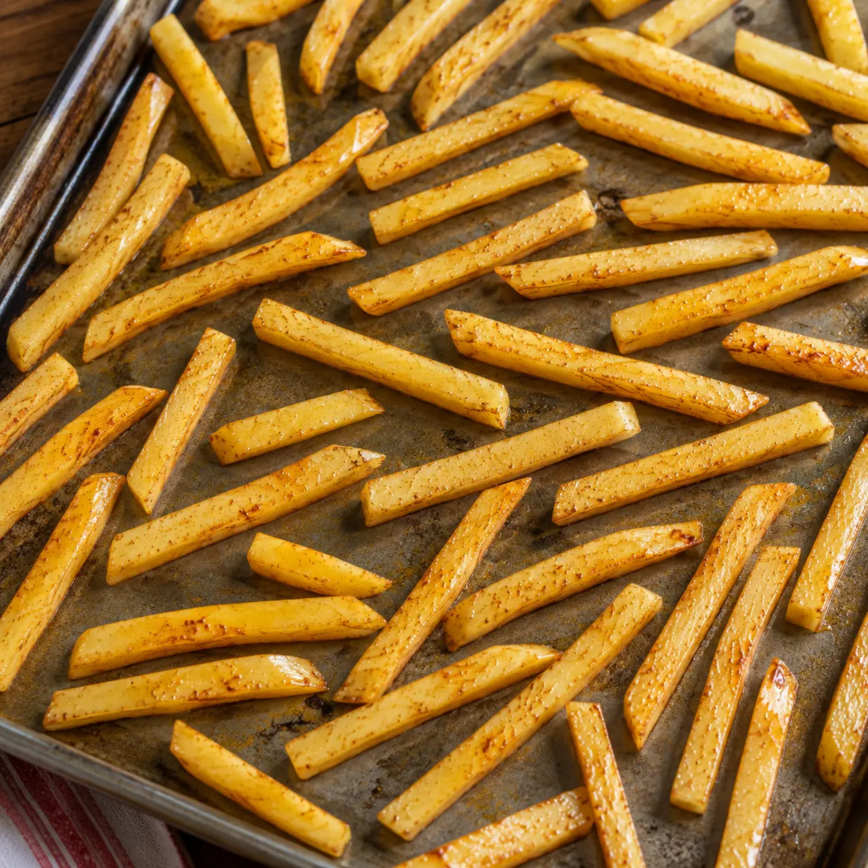 Bâtonnets de pommes de terre étalés en une seule couche sur la plaque
